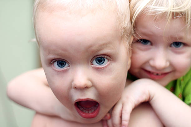 sister hugging a brother stock photo