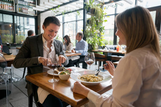 Loving couple having dinner together at a restaurant and looking very happy - food and drinks concepts