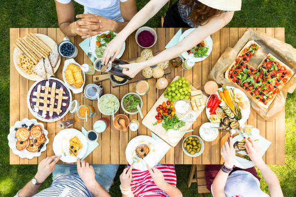vue de dessus d’une table avec une cuisine italienne et des amis, manger et boire dans le jardin - refreshment dinner table vegetable photos et images de collection