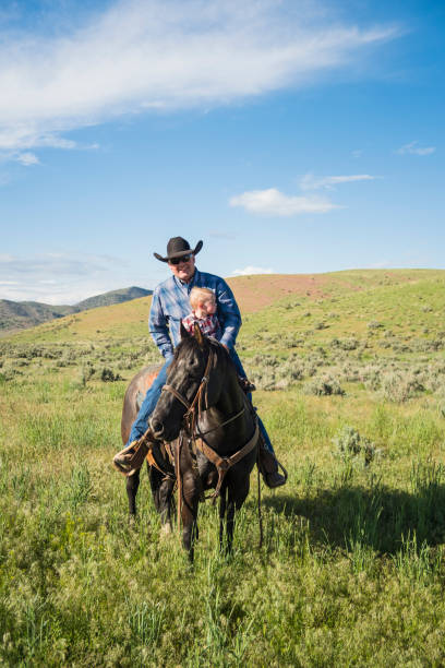 istock Cowboy Holds A Baby In The Field 981248562