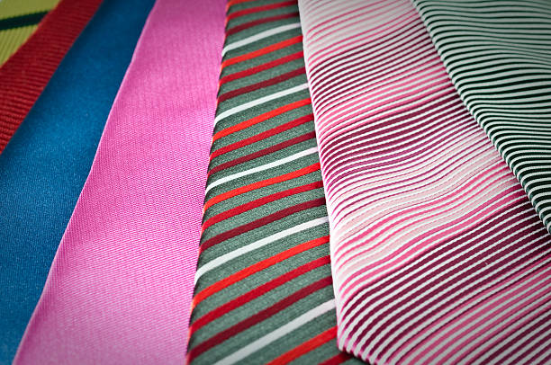 Display of neck wear in a fine men's cloting store. Arranged by color they are draped over a wooden rack.