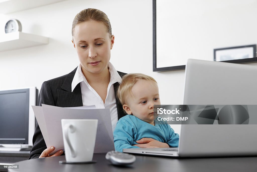 Mujer de negocios trabajar desde casa holding her baby son - Foto de stock de Adulto libre de derechos