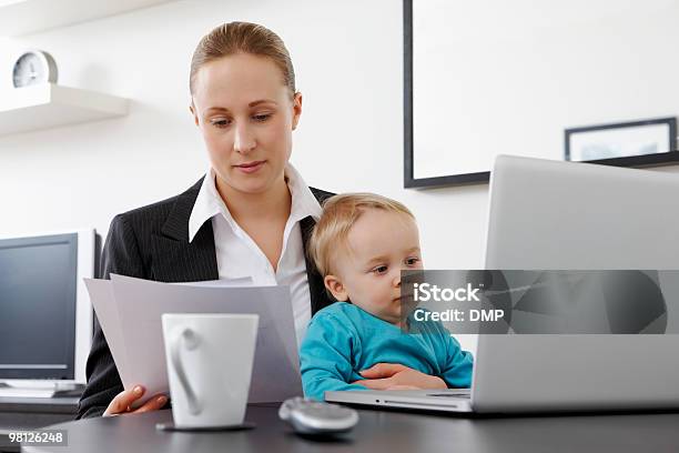 Mujer De Negocios Trabajar Desde Casa Holding Her Baby Son Foto de stock y más banco de imágenes de Adulto