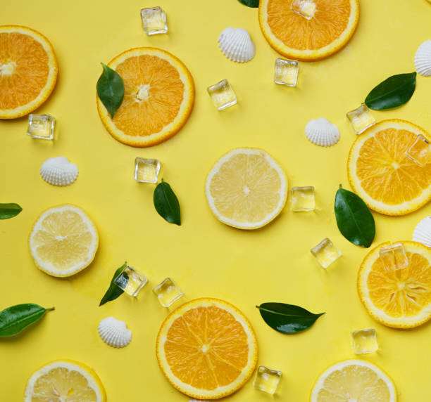 istock Lemon Orange Leaves Cube Ice Sea Shells Citrus Pattern on Yellow Background Minimal Flat Lay 981273986