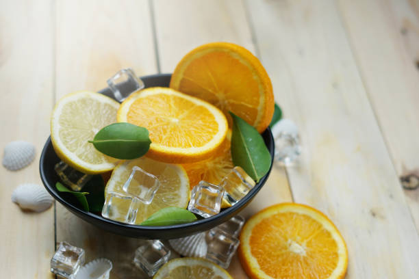 Lemon Orange Leaves Cube Ice Sea Shells Citrus in a Black Bowl