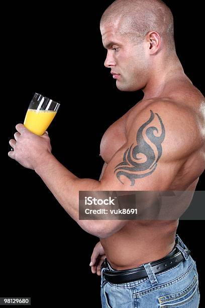 Muscular Man Beber Jugo Foto de stock y más banco de imágenes de Abdomen humano - Abdomen humano, Actividades y técnicas de relajación, Adulto