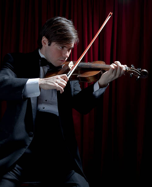 giovane uomo in smoking suona il violino - classical music red violin bow foto e immagini stock