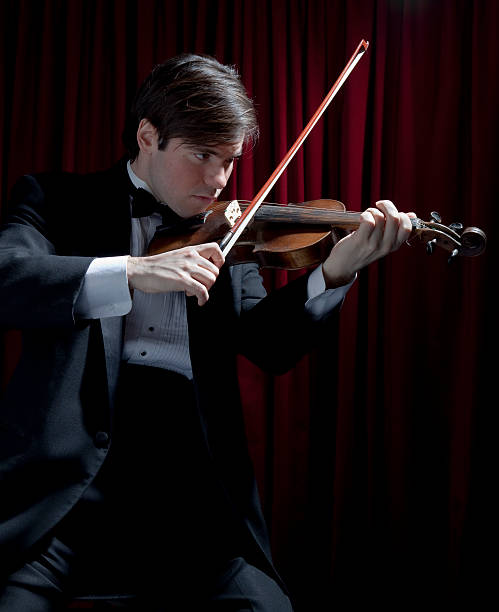 istock Young man in tuxedo playing violin 98131347