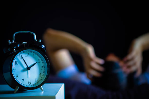 азиатский человек в постели страдает бессонницей и расстройством сна думать о своей проблеме в ночное время - insomnia стоковые фото и изображения