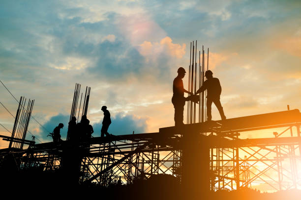 silhueta da equipe de engenharia e construção, trabalhando no local mais pastel do sol de fundo desfocado para fundo de indústria com luz justo. crie juntos a partir de várias imagens de referência. - construction - fotografias e filmes do acervo