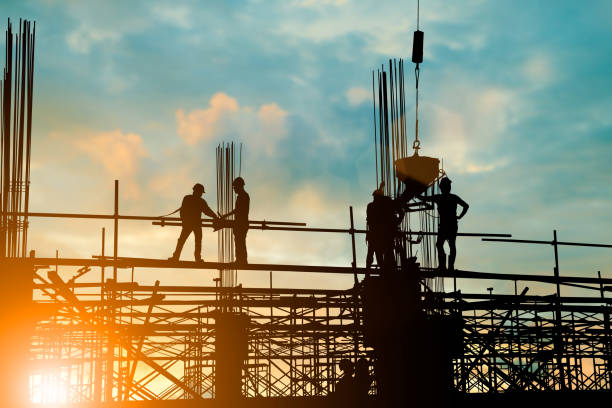 istock Silhouette of engineer and construction team working at site over blurred background sunset pastel for industry background with Light fair.Create from multiple reference images together. 981340330