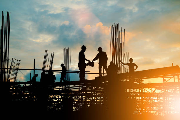 istock Silhouette of engineer and construction team working at site over blurred background sunset pastel for industry background with Light fair.Create from multiple reference images together. 981340804