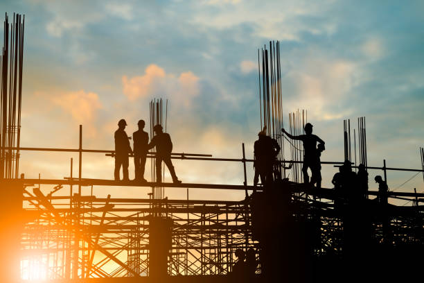 istock Silhouette of engineer and construction team working at site over blurred background sunset pastel for industry background with Light fair.Create from multiple reference images together. 981343098