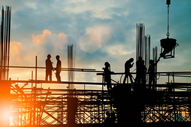 istock Silhouette of engineer and construction team working at site over blurred background sunset pastel for industry background with Light fair.Create from multiple reference images together. 981343658