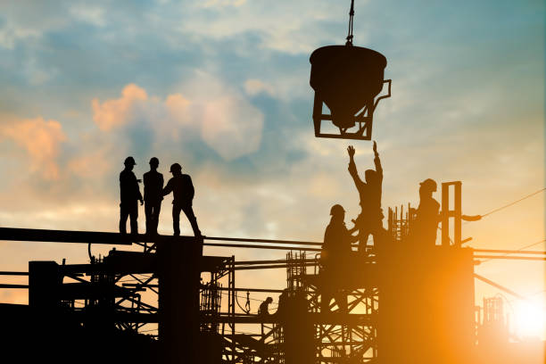 istock Silhouette of engineer and construction team working at site over blurred background sunset pastel for industry background with Light fair.Create from multiple reference images together. 981343902