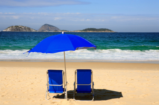 Chair and umbrella perfectly placed on a serene beach invites relaxation, capturing the essence of seaside serenity and the promise of a peaceful escape