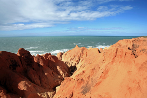 Stunning red Pindan cliffs adjoining the turquoise blue sea at James Price Point,  North of Broome in the remote Kimberley region of Western Australia.