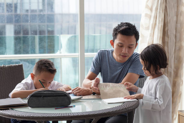 istock Malay male with young boy and girl doing homework 981383600
