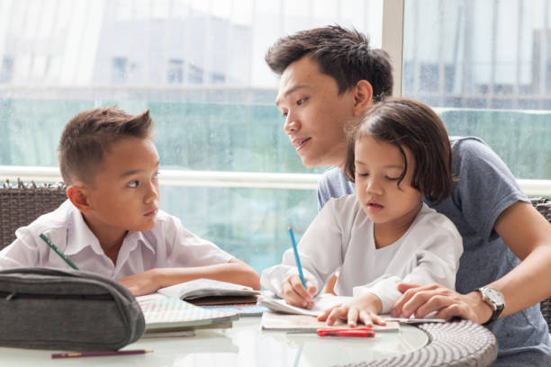 istock Malay male with young boy and girl doing homework 981384308