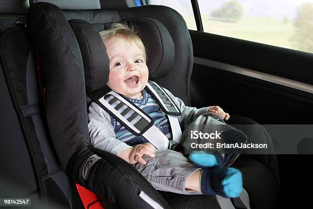 Bambino Nel Seggiolino Di Sicurezza Di Suoa Figlioa - Fotografie stock e altre immagini di Seggiolino per auto