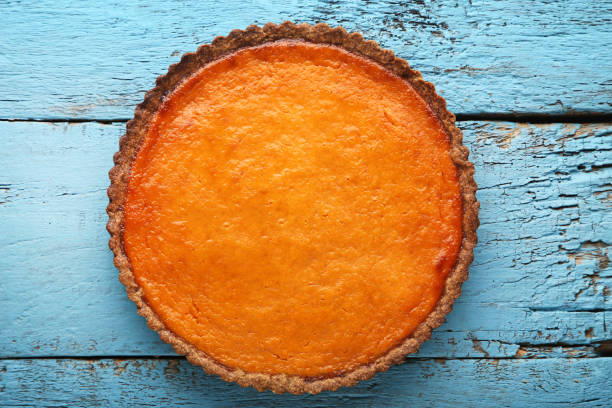 istock Pumpkin tart on blue wooden table 981434484