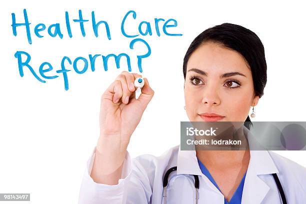 A Woman Writing Health Care Reform On A Board Stock Photo - Download Image Now - Adult, Brainstorming, Brown Hair