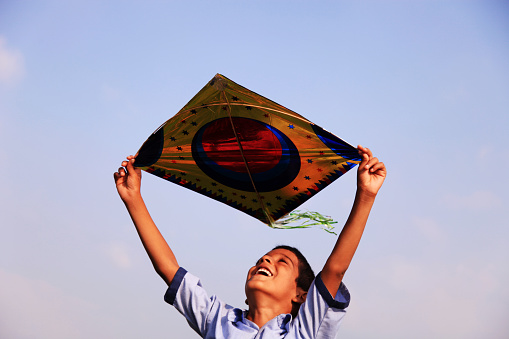 Child holding kite in hands outdoor in the nature.