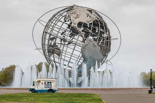 Flushing Meadows Corona Park, Queens, New York, USA – May 5, 2018: A ice cream truck in front of the world sculpture sphere