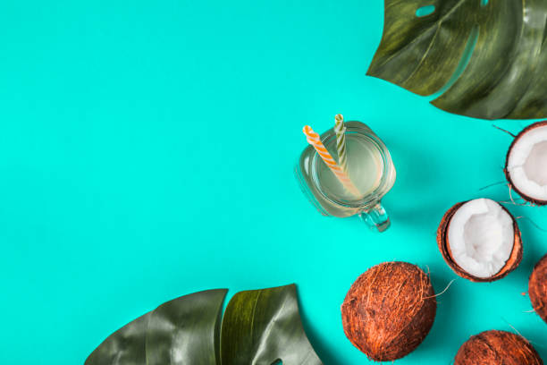 istock Coconut water and coconuts on a background with tropical leaves 981463008
