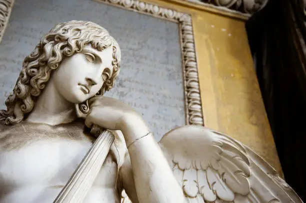 Old statue of an angel inside the monumental cemetery of the Certosa di Bologna. The public cemetery was established in 1801.
