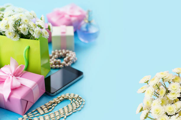 dekorative komposition boxen mit geschenke blumen frauen schmuck shopping urlaub blauen hintergrund. - pink perfume bracelet necklace stock-fotos und bilder