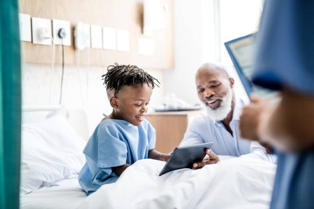 uomo mostra tablet pc a nipote malato in ospedale - grandparent family multi generation family technology foto e immagini stock