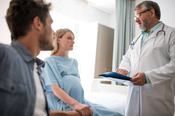 istock Doctor explaining pregnant woman sitting with man 981469296