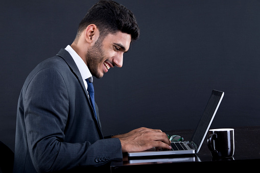 Busy businessman typing on a laptop at office desk