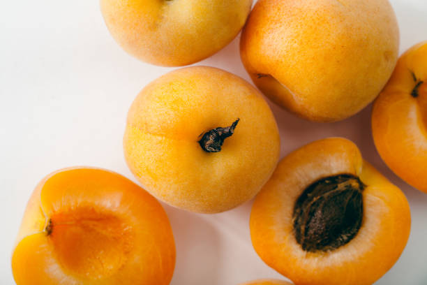 istock Fresh apricots whole and sliced on white background. Copy space 981482882