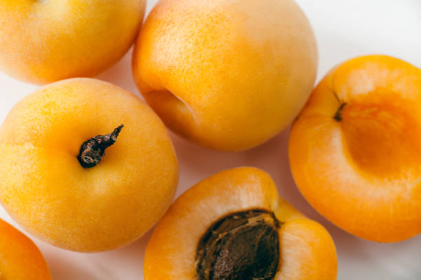 istock Fresh apricots whole and sliced on white background. Copy space 981482980