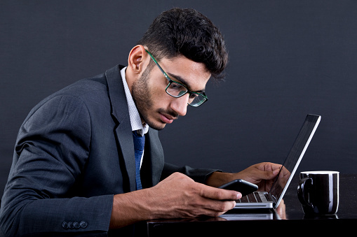 Busy businessman typing on a laptop at office desk