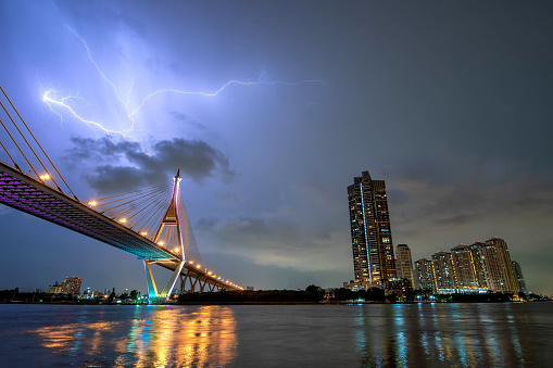 Bangkok city - cityscape urban bridge at night chao phraya river and lightning  thunder background , landscape bangkok Thailand
