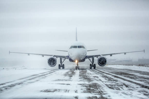 Airliner on runway in blizzard. Aircraft during taxiing during heavy snow. Passenger plane in snow at airport. Modern twin-engine passenger airplane taxiing for take off at airport during snow blizzard Airliner on runway in blizzard. Aircraft during taxiing during heavy snow. Passenger plane in snow at airport. Modern twin-engine passenger airplane taxiing for take off at airport during snow blizzard airfield stock pictures, royalty-free photos & images