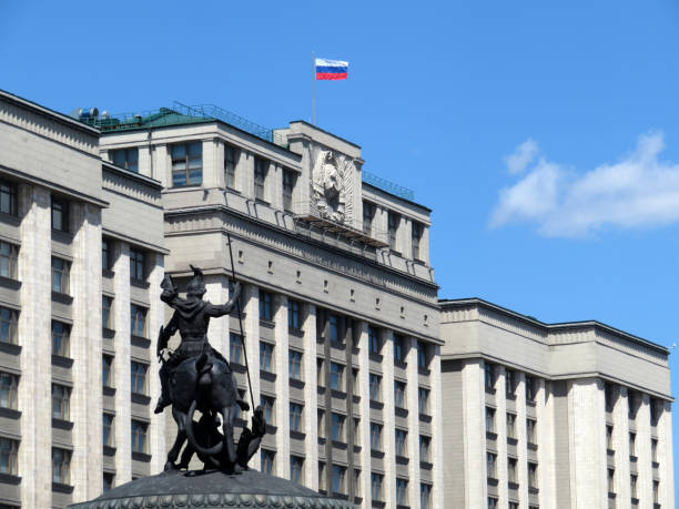 bandera rusa en el edificio del parlamento en moscú contra el cielo azul nublado. estado duma y estatua de san jorge el victorioso - hoz y martillo fotografías e imágenes de stock
