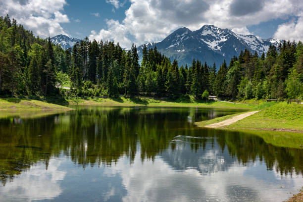 Reflections on lake Lottensee near Seefeld and Mösern in the Austrian Alps. The lake only appears at irregular intervals in springtime, sometimes spanning many years, and disappears in the autumn.
