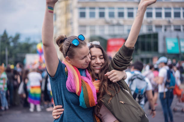 istock Beautiful female couple hugging while marching on the street 981512680