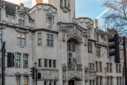 The art nouveau Gothic facade of The Middlesex Guildhall which is the home of the Supreme Court of the UK. The exterior of the building is decorated with corner turrets, a piecework parapet, and many ornamental statues by sculptor Henry Fehr. The impressive relief frieze and statues are over the entrance.