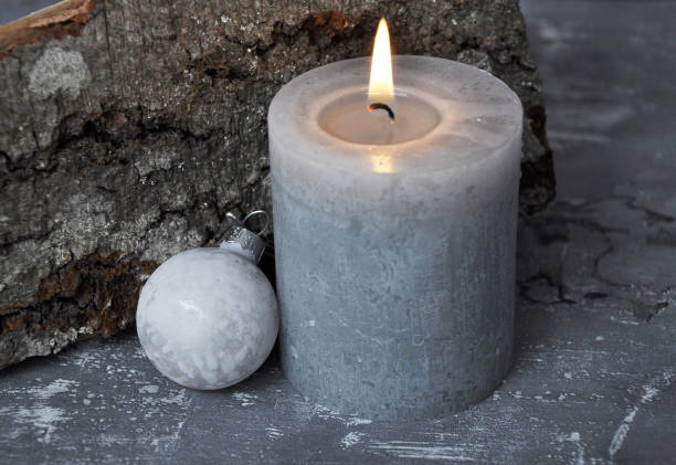 istock Burning candle, Christmas tree bauble and wood billet on concrete 981521748