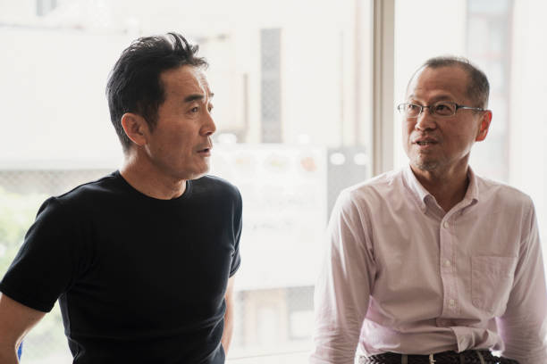 istock Two senior male friends talking happily at the window 981523018