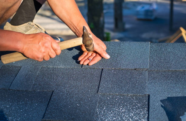istock Worker repair corner bitumen roof shingles with hammer and nails. 981526432