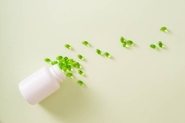 istock green capsules spilling out of a bottle 981527418