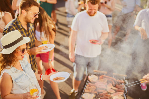istock Group of people standing around grill. 981531276