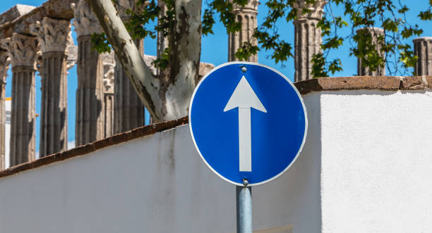 bleu tour de panneau de signalisation avant seulement devant les ruines d’un temple romain - curve road in front of sign photos et images de collection