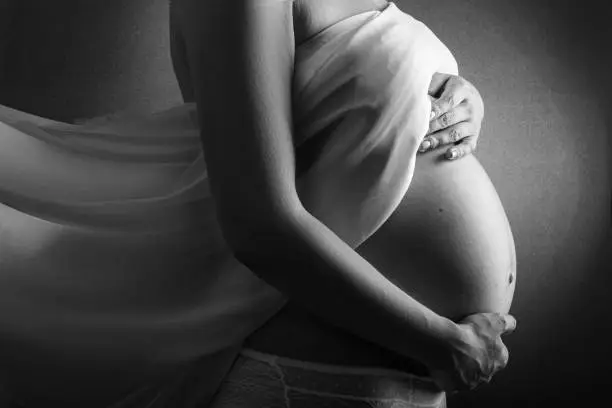 pregnant woman, black and white photo of pregnancy in the eighth month.Pregnant Woman Belly. Pregnancy Concept. Isolated on Black Background. Black and white pregnant tummy close up